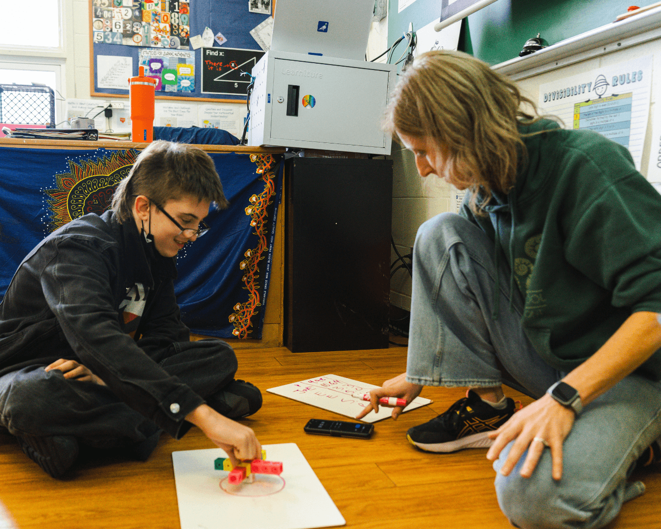 Teacher and student work on hands-on math project together