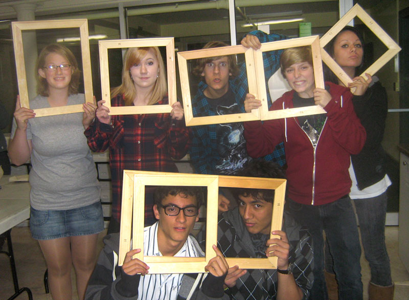 students holding picture frames
