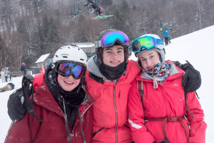 3 teens posing for a picture on the ski slopes