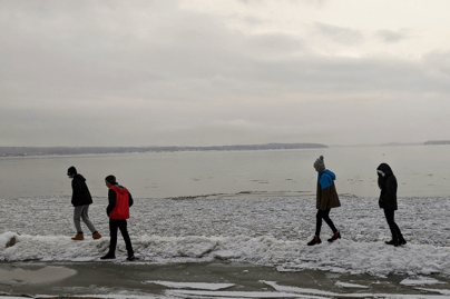 A group of teens taking a walk along Lake Champlain