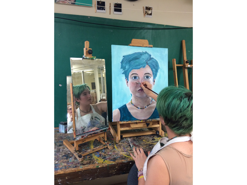 Student painting a self-portrait