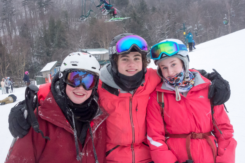 3 teens posing for a picture together on the ski slopes